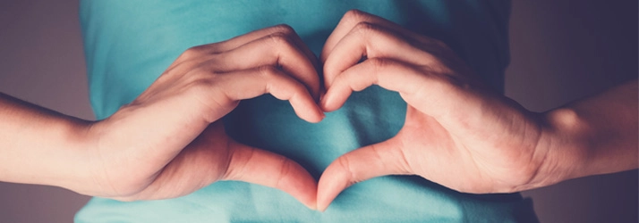 Functional Medicine The Colony TX Heart Hands A person making heart hands over their stomach.